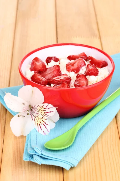 Queso de cabaña en tazón rojo con fresas en rodajas en la mesa de madera —  Fotos de Stock