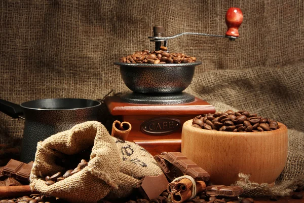 Coffee grinder, turk and cup of coffee on burlap background — Stock Photo, Image