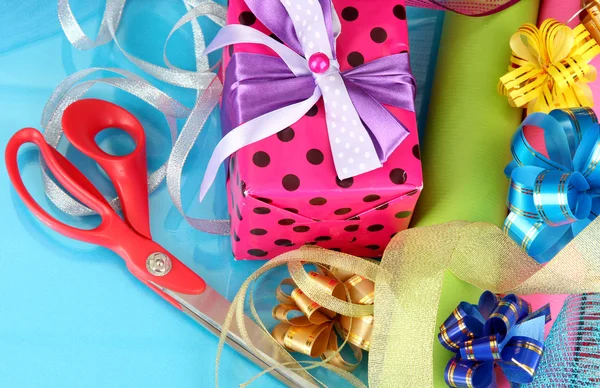 Rouleaux de papier d'emballage de Noël avec rubans, noeuds sur fond de couleur — Photo