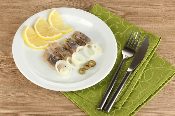 Plato de arenque y limón en plato sobre mesa de madera primer plano —  Fotos de Stock