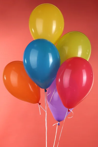 Kleurrijke ballonnen op rode achtergrond — Stockfoto