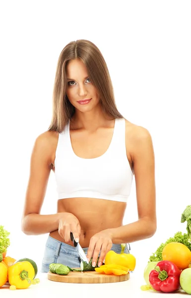 Bela jovem mulher cortando legumes, isolado em branco — Fotografia de Stock