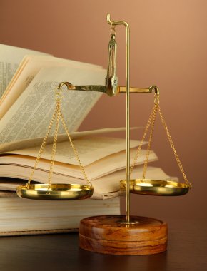 Adalet ve kitap kahverengi zemin üzerine Altın pul