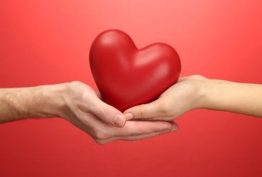 kadın ve adam ellerini, kırmızı zemin üzerine kırmızı kalp