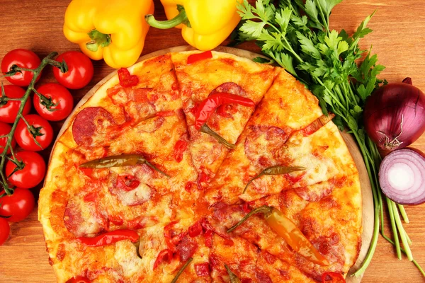 Sabrosa pizza de pepperoni con verduras sobre tabla de madera sobre fondo de madera —  Fotos de Stock