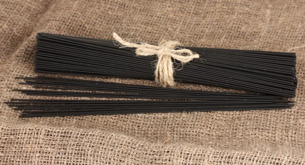 Black spaghetti on sackcloth background — Stock Photo, Image