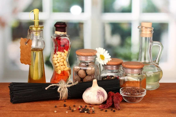 Esparguete de massas, legumes e especiarias na mesa de madeira no fundo brilhante — Fotografia de Stock