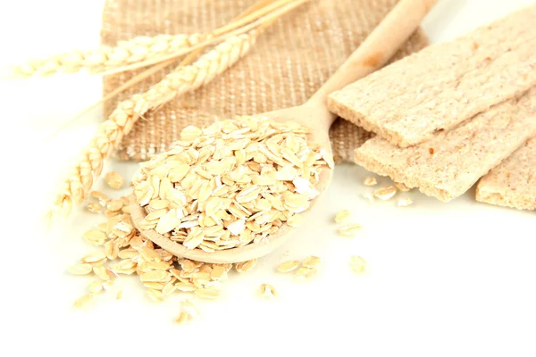 Fiocchi d'avena in cucchiaio di legno con spighette e biscotti d'avena isolati su bianco — Foto Stock