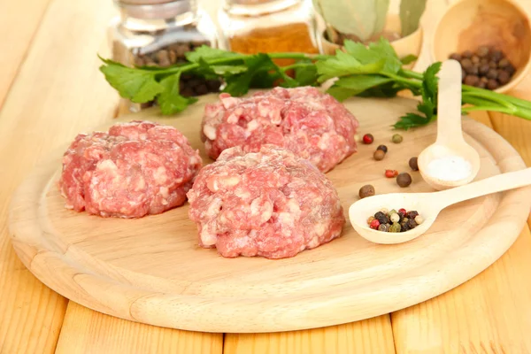 Raw meatballs with spices on wooden table — Stock Photo, Image