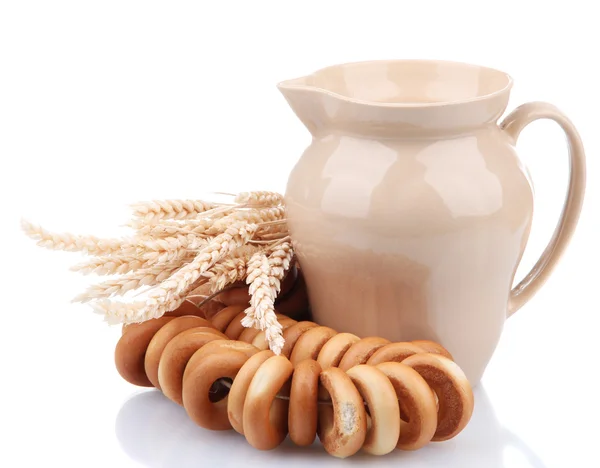 Jar of milk, tasty bagels and spikelets, isolated on white — Stock Photo, Image