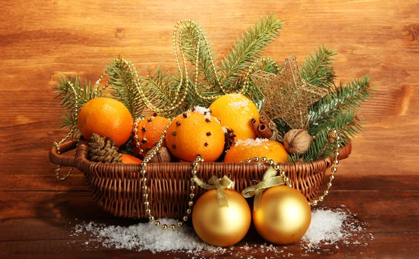 Kerstmis samenstelling in de mand met sinaasappels en fir tree, op houten achtergrond — Stockfoto