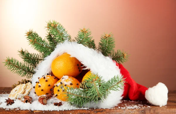 Рождественская композиция с апельсинами и елкой в шляпе Санта-Клауса — стоковое фото