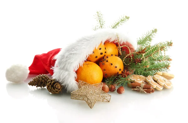 Weihnachtskomposition mit Orangen und Tanne in Weihnachtsmannmütze, isoliert auf weiß — Stockfoto