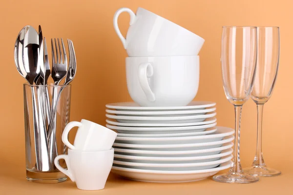 Čisté bílé nádobí na béžové pozadí — Stock fotografie