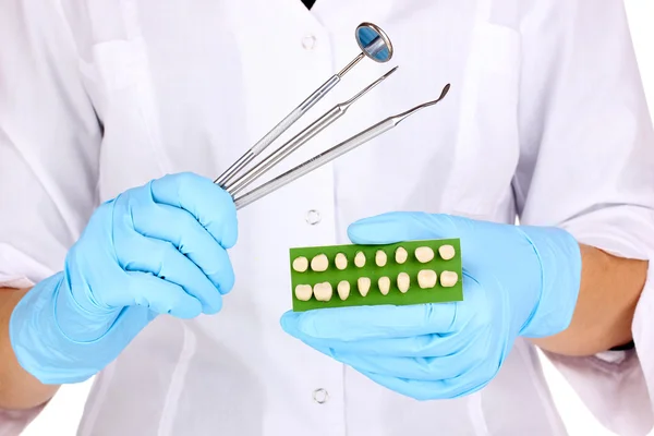 Dentistas mãos em luvas médicas azuis com ferramentas odontológicas e dentadura — Fotografia de Stock