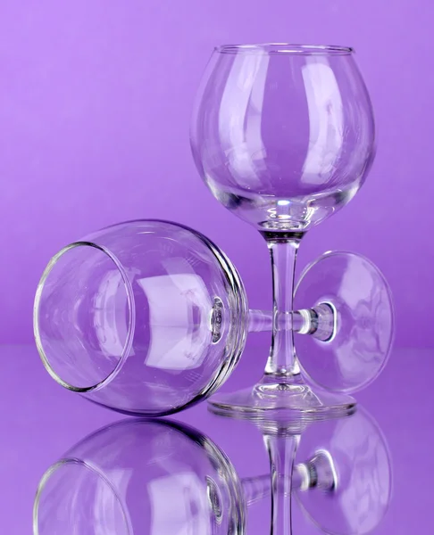 Dois copos de vinho vazios no fundo da cor — Fotografia de Stock