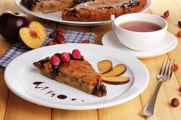 Torta saborosa na placa na mesa de madeira — Fotografia de Stock