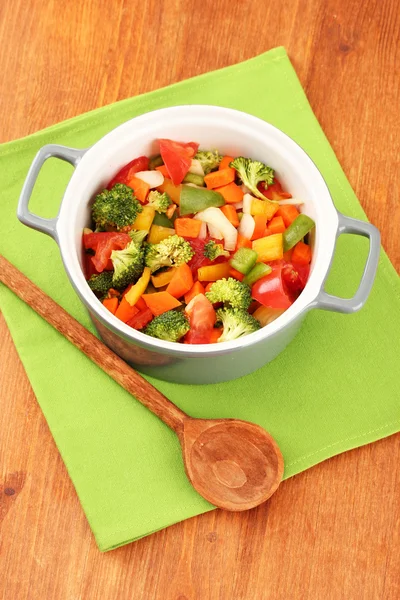 Guisado de legumes no pote cinza no guardanapo de cor no fundo de madeira — Fotografia de Stock