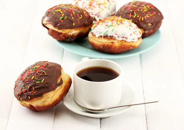 Tasty donuts on color plate on light wooden background — Stock Photo, Image