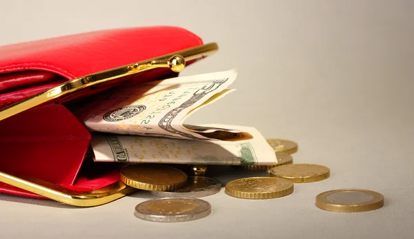 Samice červená peněženka s penězi na šedém pozadí — Stock fotografie
