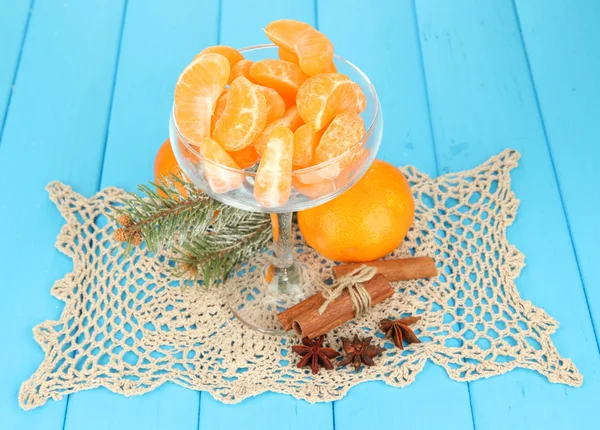 Fatias de tangerina saborosas em tigela de vidro no fundo azul — Fotografia de Stock