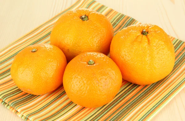 Smakelijke mandarijnen op servet op lichte achtergrond — Stockfoto