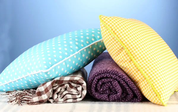 Plaids y almohadas de color sobre fondo azul — Foto de Stock
