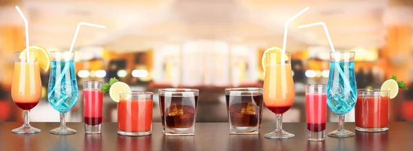 Several glasses of different drinks on bright background — Stock Photo, Image