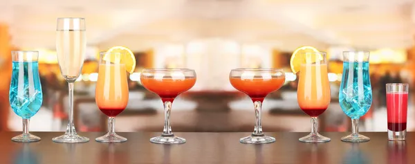 Several glasses of different drinks on bright background — Stock Photo, Image