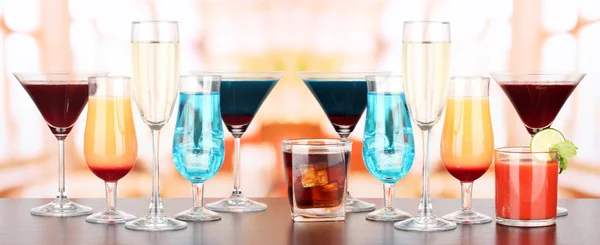 Several glasses of different drinks on bright background — Stock Photo, Image