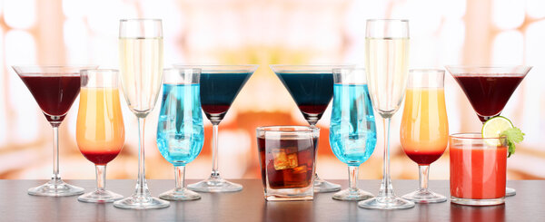 Several glasses of different drinks on bright background