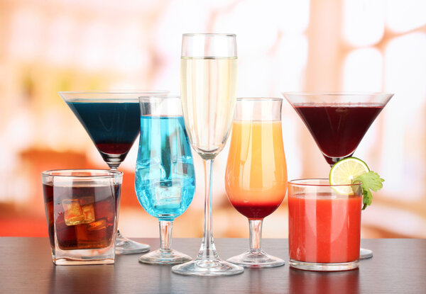 Several glasses of different drinks on bright background