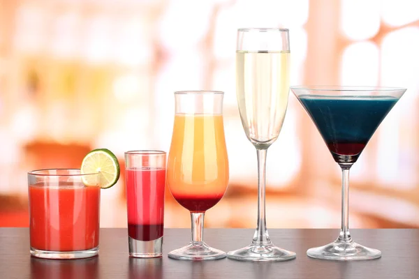 Several glasses of different drinks on bright background — Stock Photo, Image