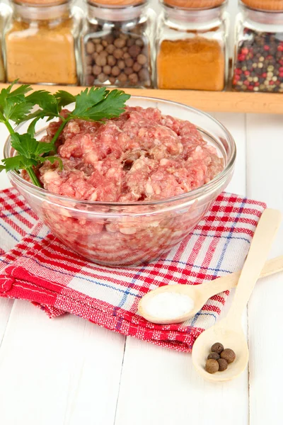 Bowl of raw ground meat with spices on wooden table Stock Image
