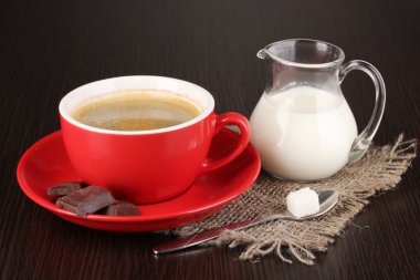 Kırmızı çikolata ve ahşap masa üzerinde süt ile Türk kahvesi fincan