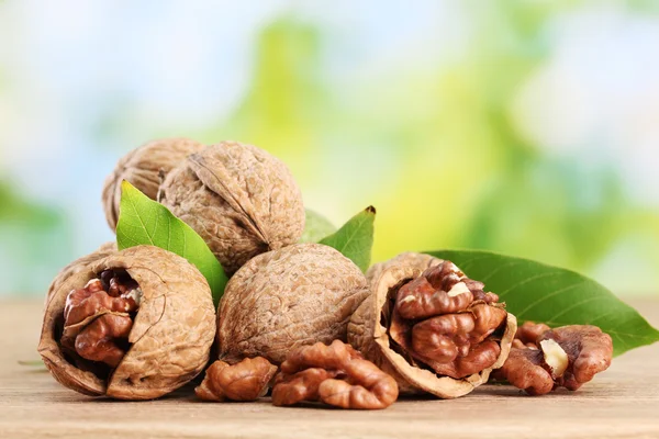 Nueces con hojas verdes, sobre fondo verde — Foto de Stock