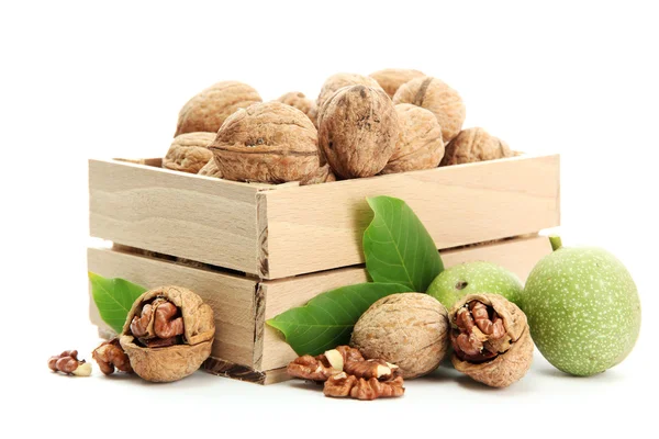 Nueces con hojas verdes en caja de madera, aisladas en blanco —  Fotos de Stock