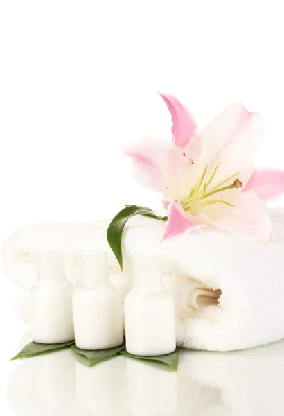 Красивая лилия с полотенцем и бутылки изолированы на белом — стоковое фото