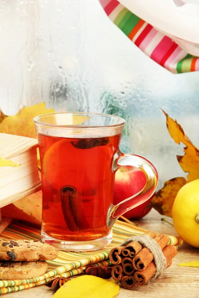 Cup of hot tea and autumn leaves, on wooden table — Stock Photo, Image