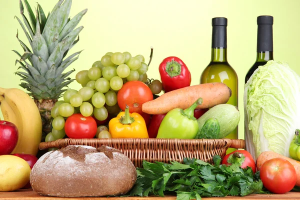 Složení zeleniny a ovoce v proutěném koši na zeleném pozadí — Stock fotografie
