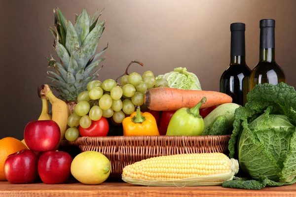 Kompozycja z warzyw i owoców w wiklinowym koszu na brązowym tle — Zdjęcie stockowe