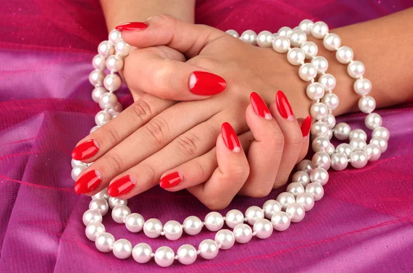 Female hands holding beads on color background — Stock Photo, Image