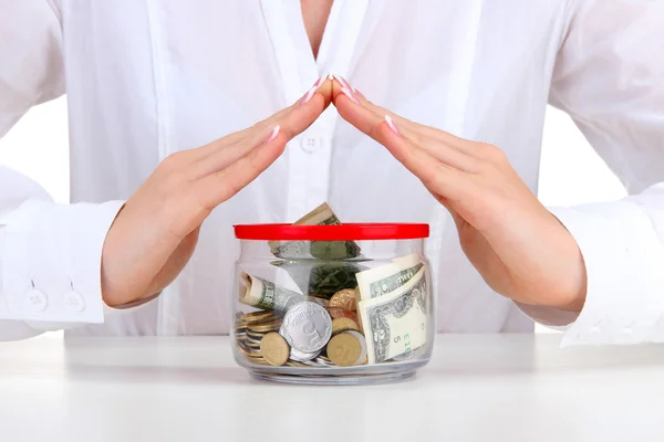 Vrouw handen met geld in glazen pot, close-up — Stockfoto