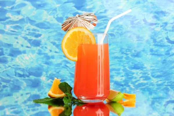 Glass of orange cocktail on blue background — Stock Photo, Image