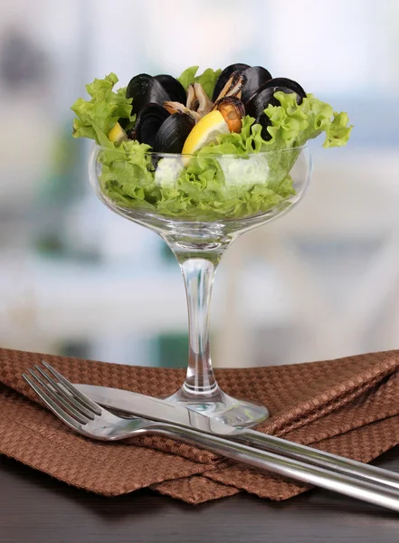 Snack of mussels and lemon on vase on wooden table on room background — Stock Photo, Image