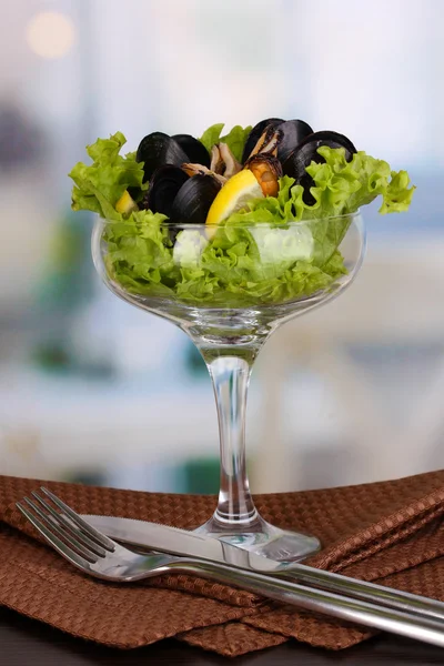 Snack of mussels and lemon on vase on wooden table on room background — Stock Photo, Image