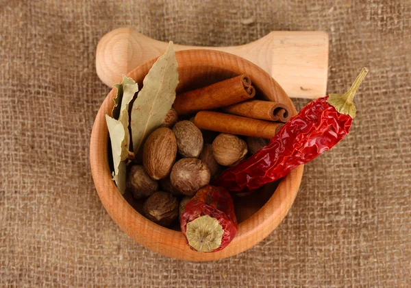 Nutmeg and other spices on sackcloth background — Stock Photo, Image