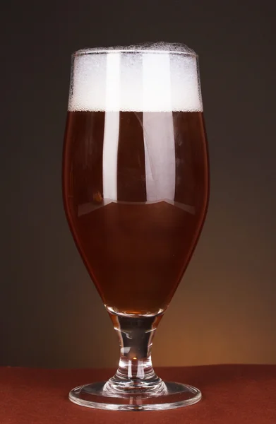 Glass of beer on brown background — Stock Photo, Image