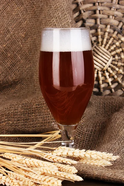 木製のテーブル バック グラウンドを袋に入れて上にビールのグラス — ストック写真