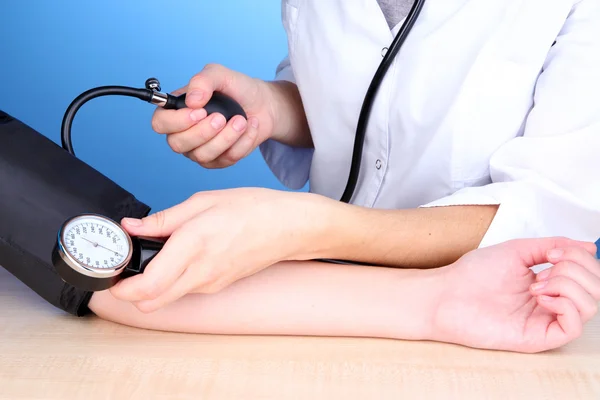 Misurazione della pressione sanguigna su sfondo blu — Foto Stock
